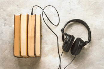 Books,And,Headphones,Connected,To,Them,On,A,White,Stone