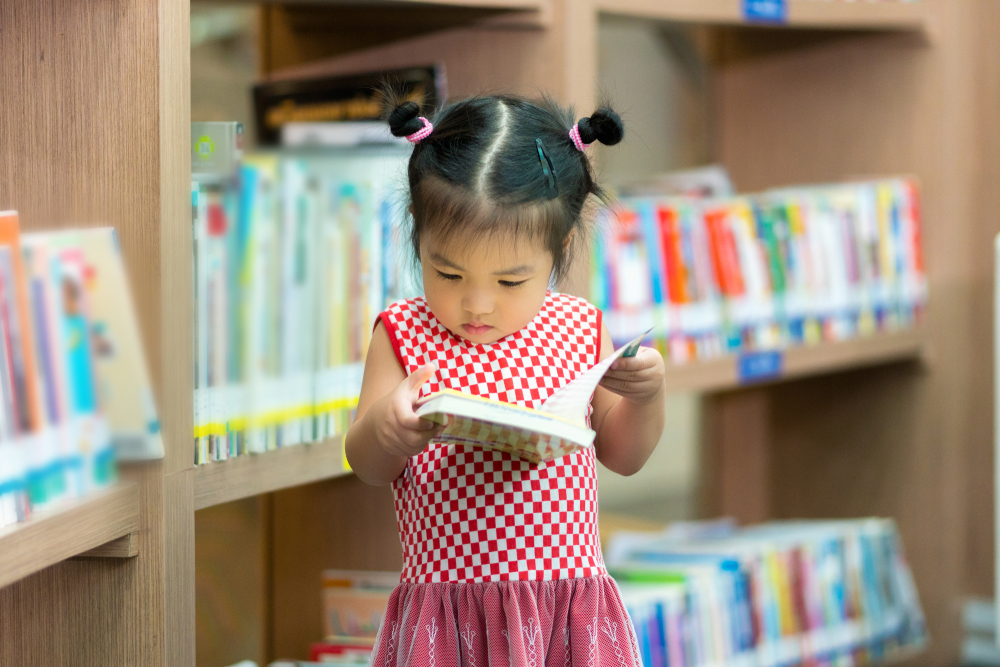 Little,Girl,Indoors,In,Front,Of,Books.,Cute,Young,Toddler