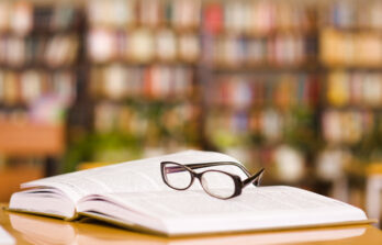 Book,And,Glasses,On,Table,In,Library