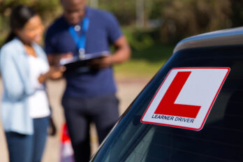 African,Learner,Driver,And,Instructor,Behind,A,Car