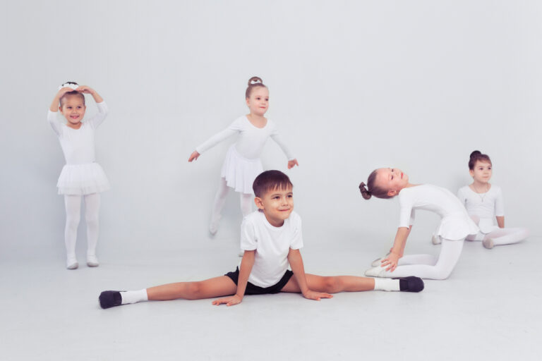 Little,Ballerinas,Girls,And,Boy,Doing,Splits,On,White,Floor,