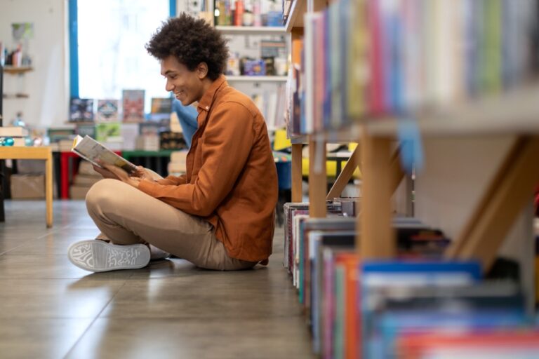 Black,Student,Guy,Reading,Book,While,Sitting,On,Floor,Near