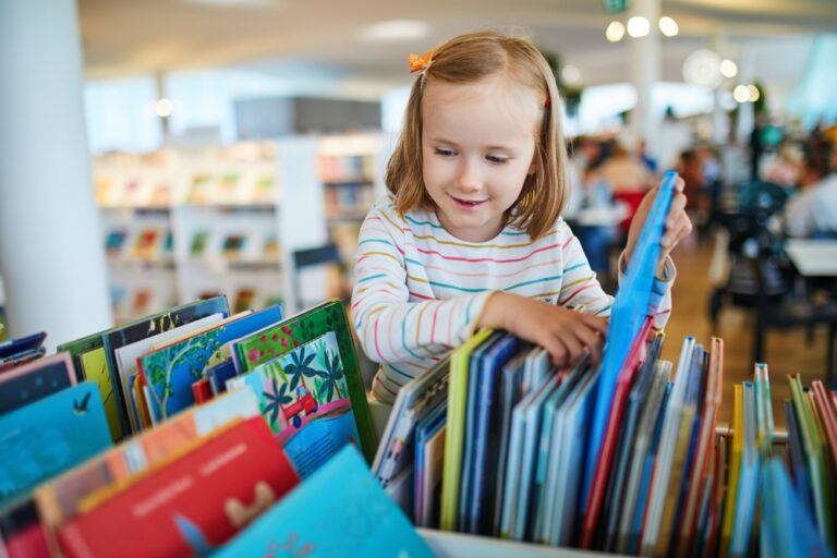 Five,Year,Old,Girl,Selecting,A,Book,In,Municipal,Library