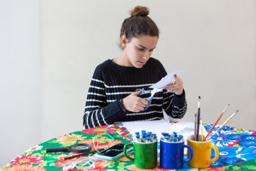 Young,Talented,Woman,Artist,Sitting,At,Flowered,Table,With,Pencils,