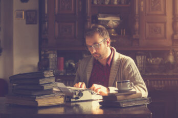Young,Man,Writing,On,Old,Typewriter.